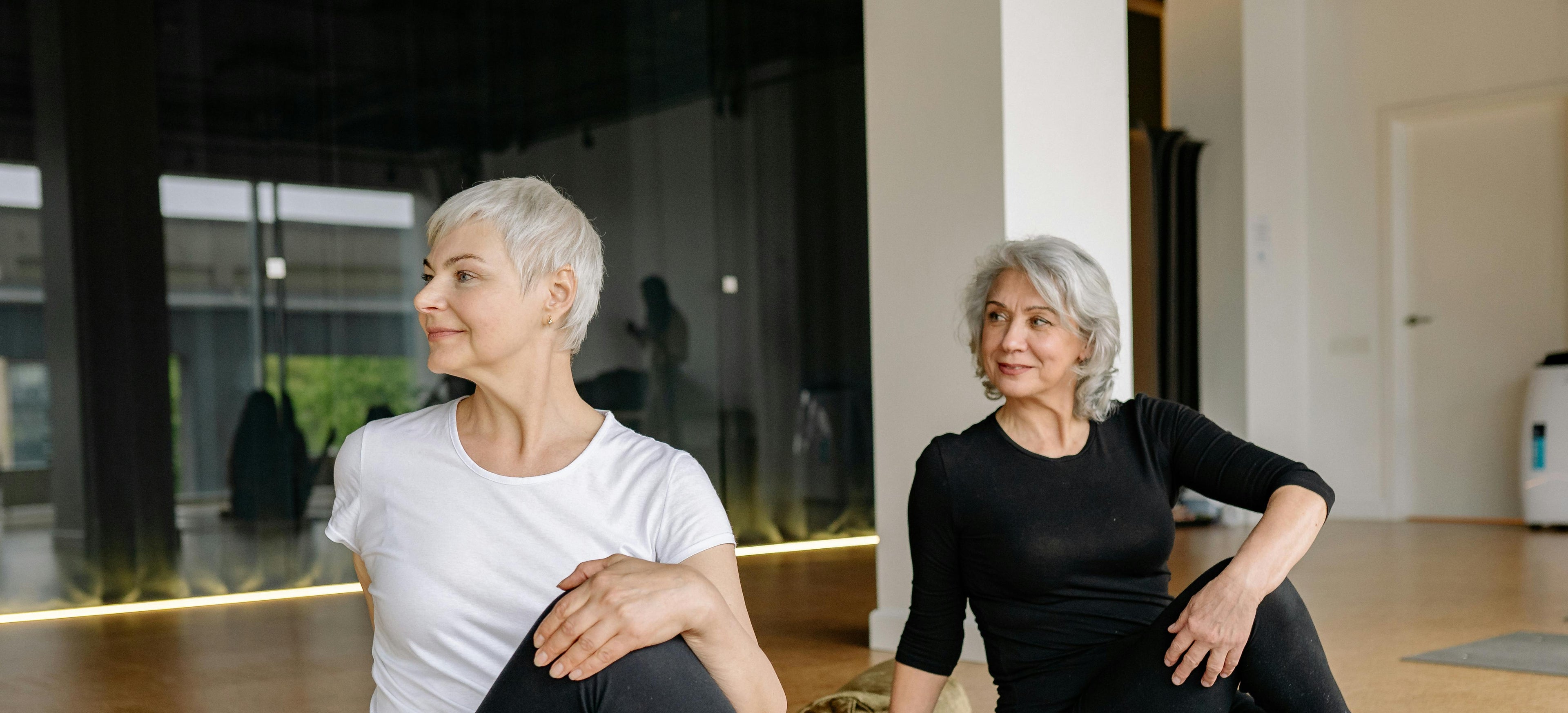 Two women practicing yoga in a modern indoor setting
